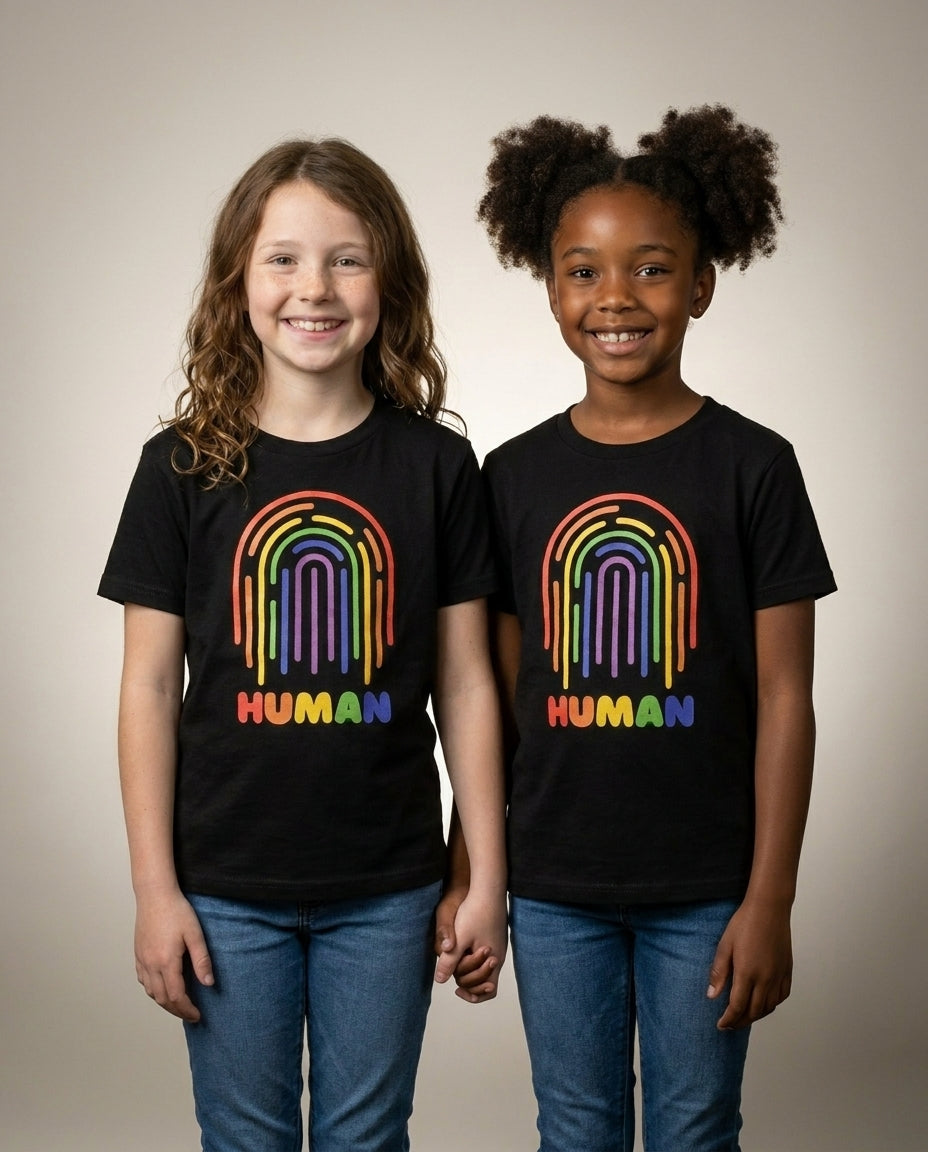 Two kids holding hands in the HUMAN Pride youth tee