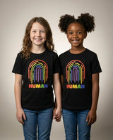 Two kids holding hands in the HUMAN Pride youth tee
