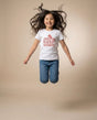 Youth jumping in Keep Going tee